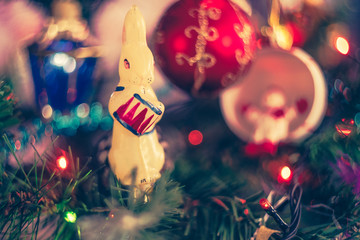 Christmas atmospheric background. A close-up fragment of a Christmas tree with toys, lights of gerland