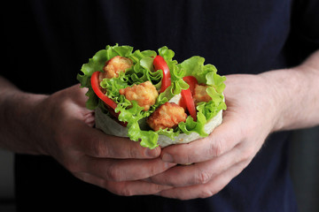 Shawarma in male hands. Doner kebab. Shawarma with meat, onions, salad and tomato. Eastern food.