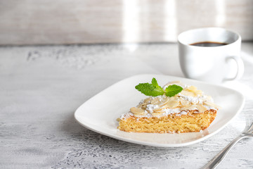 Homemade Almond cake slice on white plate and cup of coffee. Time for eat dessert background.