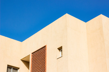 geometry pattern of bright rose house roof corners and architectural shapes on vivid blue sky background 