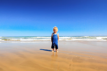 Little baby have fun on the beach.