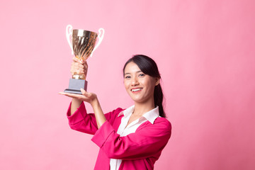 Successful young asian woman holding a trophy.