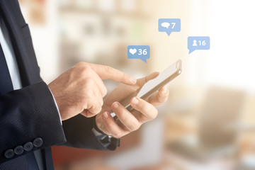 Close-up image of businessman hands using smartphone at office, searching or social networks concept