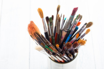 Obraz premium bunch of paint brush at tin can, on white wooden