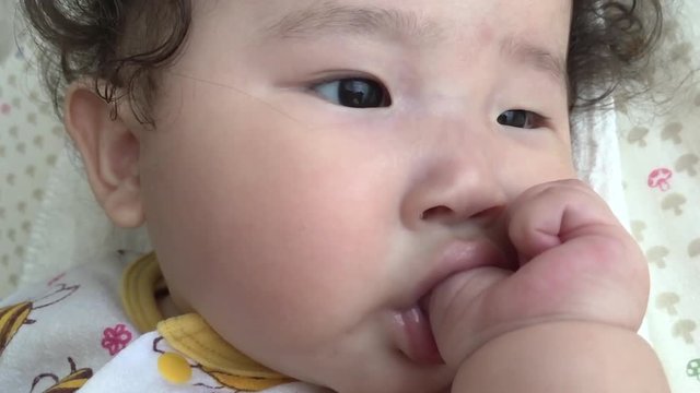 A female baby sucking a finger and falling into a sleep in slow motion