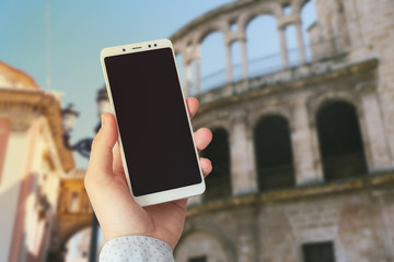 hand with a phone on the background of attractions, for travel, mock 