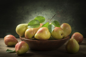still life with fresh pears with leaves in a bowl