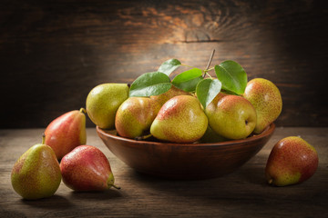 still life with fresh pears with leaves in a bowl