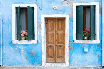 Colourful house on the island of Burano. The facade of a blue house with a laundry rack outside in Burano, Venice, Italy. Burano is near Venice, and is famous for its canals and charming. - Immagine
