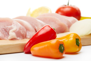 Raw turkey meat fillet and vegetables.