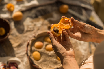 woman in gentle sundress cooking a sweet pie with fresh apricots on a sunny summer day