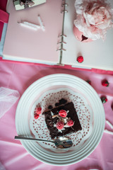 tasty homemade chocolate birthday cake decorated of some raspberries and candles served on the gentle pink background