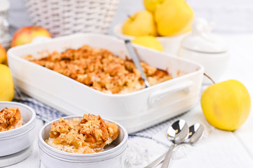 Apple pie in white ceramic baking dish. Homemade breakfast with apples and a la carte plates. Bright photo. Free space for text.