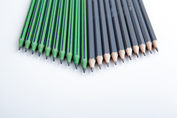 many simple pencils with erasers in a row on a white table