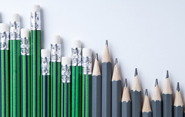 many simple pencils with erasers in a row on a white table