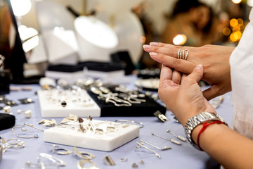 Handmade crystal market, jewelry made of silver, steel. Girl tries on the jewelry on the hand at...