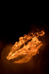 Well testing operation (flaring) of an oil and gas drilling rig. Burning huge gas flame controlled by the deluge system