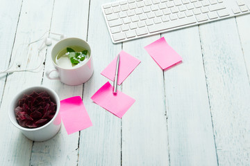 work place with cup of mint tea, pink post its, and succulent plant