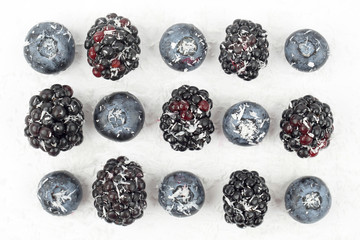 blueberries and blackberries sprinkled with coconut on white background