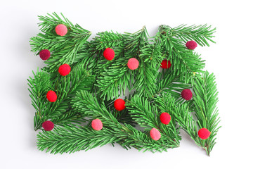 Minimalistic Christmas composition on a white background. spruce branches decorated with red balls. flat lay, top view