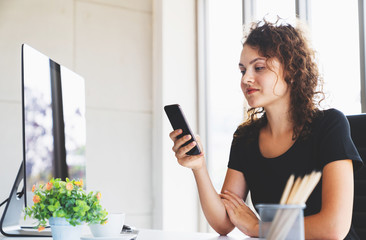Young attractive woman smiling using smartphone messaging for business in office