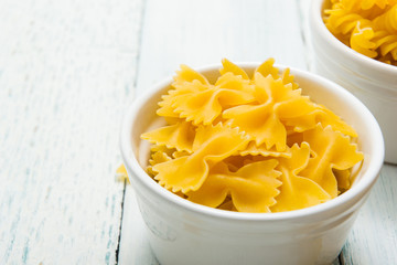uncooked pasta variations on white wood table