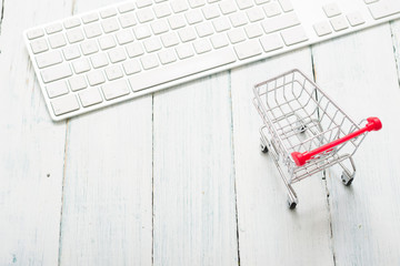 shopping cart and keypad on white wood table, web shopping background