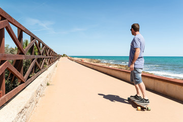 Man longboarding on a skate lane close to the sea