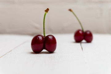 Ugly cherries on white wooden background