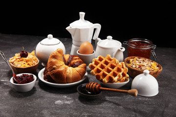Huge healthy breakfast on table with coffee, orange juice, fruits, waffles and croissants. Good morning concept.