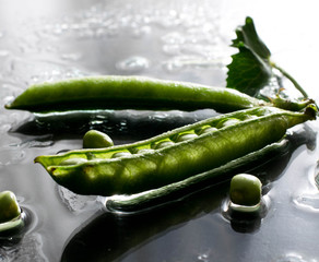  wet green peas on table