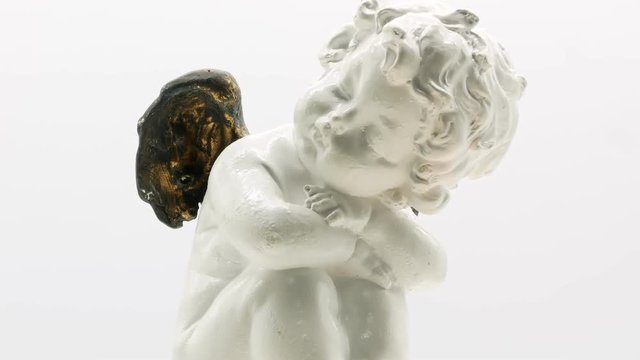 Beautiful little angel statuette on a white background 4k