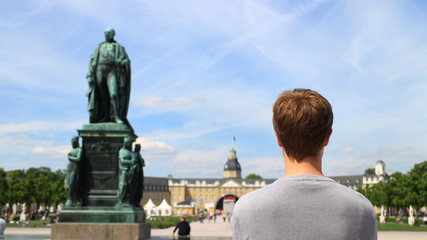 Mann schaut auf Karlsruhe Schloss farbig