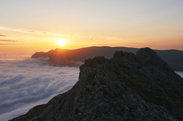 beautiful sunset above the clouds in the mountains. stunned landscape background with copy space. aerial mountain view