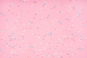 Little stars confetti on pink background. Holyday concept.