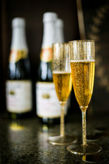 Two champagne glasses and bottles at a party