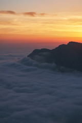 beautiful sunset above the clouds in the mountains. stunned landscape background with copy space. aerial mountain view. vertical