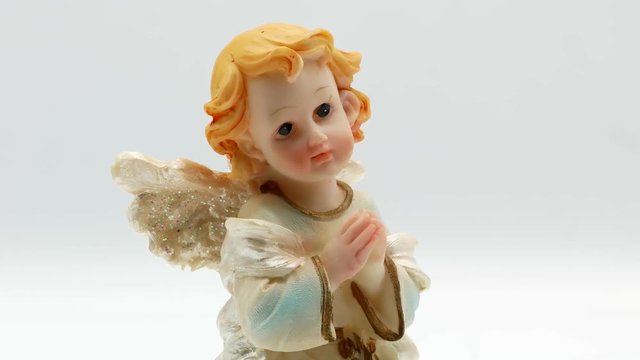 Beautiful little angel statuette on a white background 4k