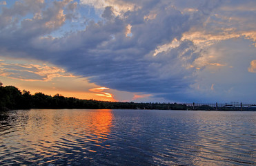 Obraz premium Big cloud at sunset near the river