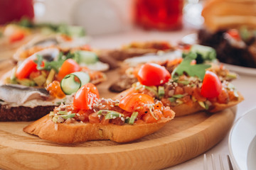 sandwich with trout, cherry tomatoes and lettuce. a plate of snacks.