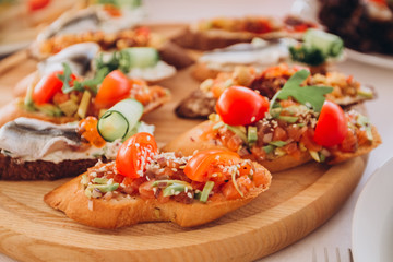 sandwich with trout, cherry tomatoes and lettuce. a plate of snacks.