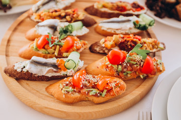 sandwich with trout, cherry tomatoes and lettuce. a plate of snacks.