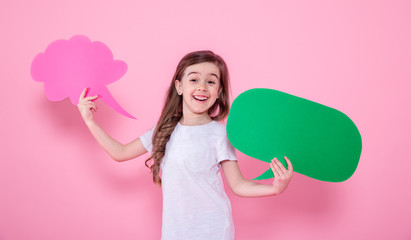 Cute little girl with an icon of a speech on a pink background