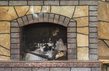 Concrete dirty fireplace with remains of ash after wooden firewood burnt in fireplace