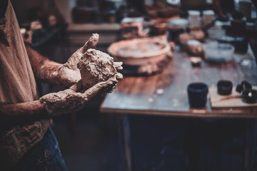 Closeup photoshoot of working process with clay by diligent man.