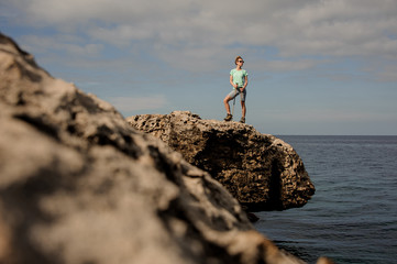 Girl standing on the rock with walking sticks