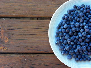 blueberries in a plate on a wooden table