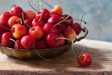 Sweet cherry berries in a bowl on the table, blur, soft focus
