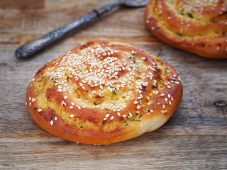 Pastry rolls made of spelt flour with zucchini and sesame, on wooden background