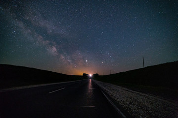Fototapeta premium The Milky Way, over the road that goes into the distance.